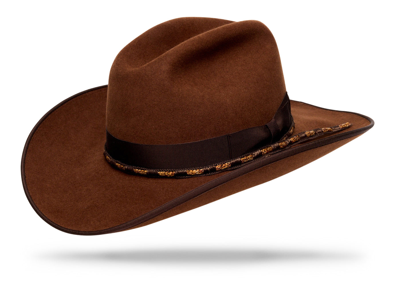 Design
Named for the outlaw who carried elegance like a weapon, The Bandolero is all presence and poise — its defiance delivered in a whisper, not a shout. The 4¼” cattleman crown and 3¾” pencil Western brim frame a silhouette of quiet conviction. Made from 100% brown beaver fur felt, it’s finished with a dark chocolate grosgrain band and a handwoven silk-and-cotton cord in contrasting tones. Each element carries tension and balance — refined, deliberate, and deeply felt. Handcrafted in our New York atelier, The Bandolero is a portrait of control and character — the calm before the draw.
Material
100% Brown Dressed Beaver Fur Felt.
Specifications
- 100%  Brown Beaver Fur Felt - 4 1/4 cattleman crown with a  3 3/4 western brim with binding. - Finished with a dark chocolate grosgrain band and a handwoven silk-and-cotton cord in contrasting tones- Handmade in our atelier in NYC.