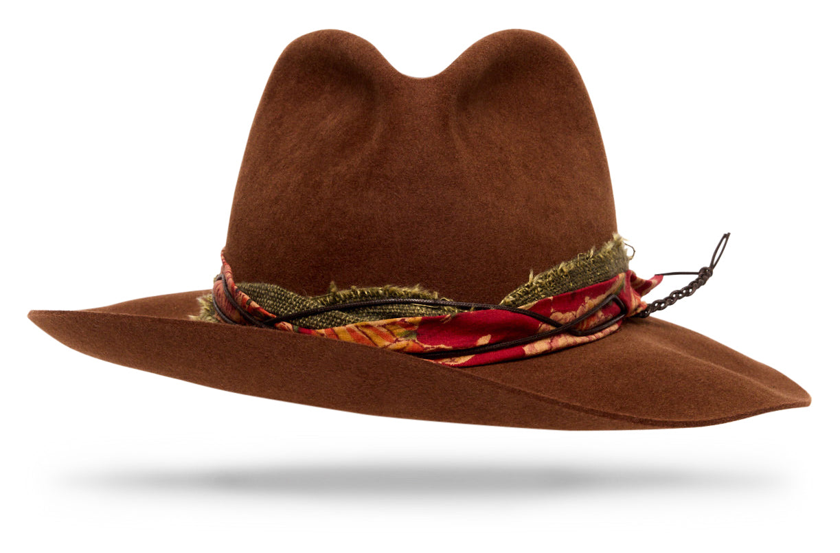 Design
A warm russet brown that softens and deepens with wear. Crafted from our softest 100% beaver felt, weighing just 90 grams, it’s impossibly light — designed to shape and collapse naturally, taking on its own form over time. The contrasting band blends Homespun Olive Kala cotton and Darjeeling block-printed cotton — two ancestral Indian textiles. Together, they bring texture, history, and quiet contrast to a hat made to move with you — effortless, lived-in, and entirely your own.
Material
100% dressed beaver sustainably acquired.
Specifications
- A dressed beaver fur felt of 90 grams is extremely soft and shapable to your desire.- 3 ¼  brim and 4 soft malleable crown.- Two contrasty hatbands: the Kala cotton band is organically grown, handspun, and handwoven in Kachchh, India, while the Darjeeling cotton is vegetable- and clay-dyed, printed with hand-carved wooden blocks.- Leather cord- Handcrafted in our NYC atelier.