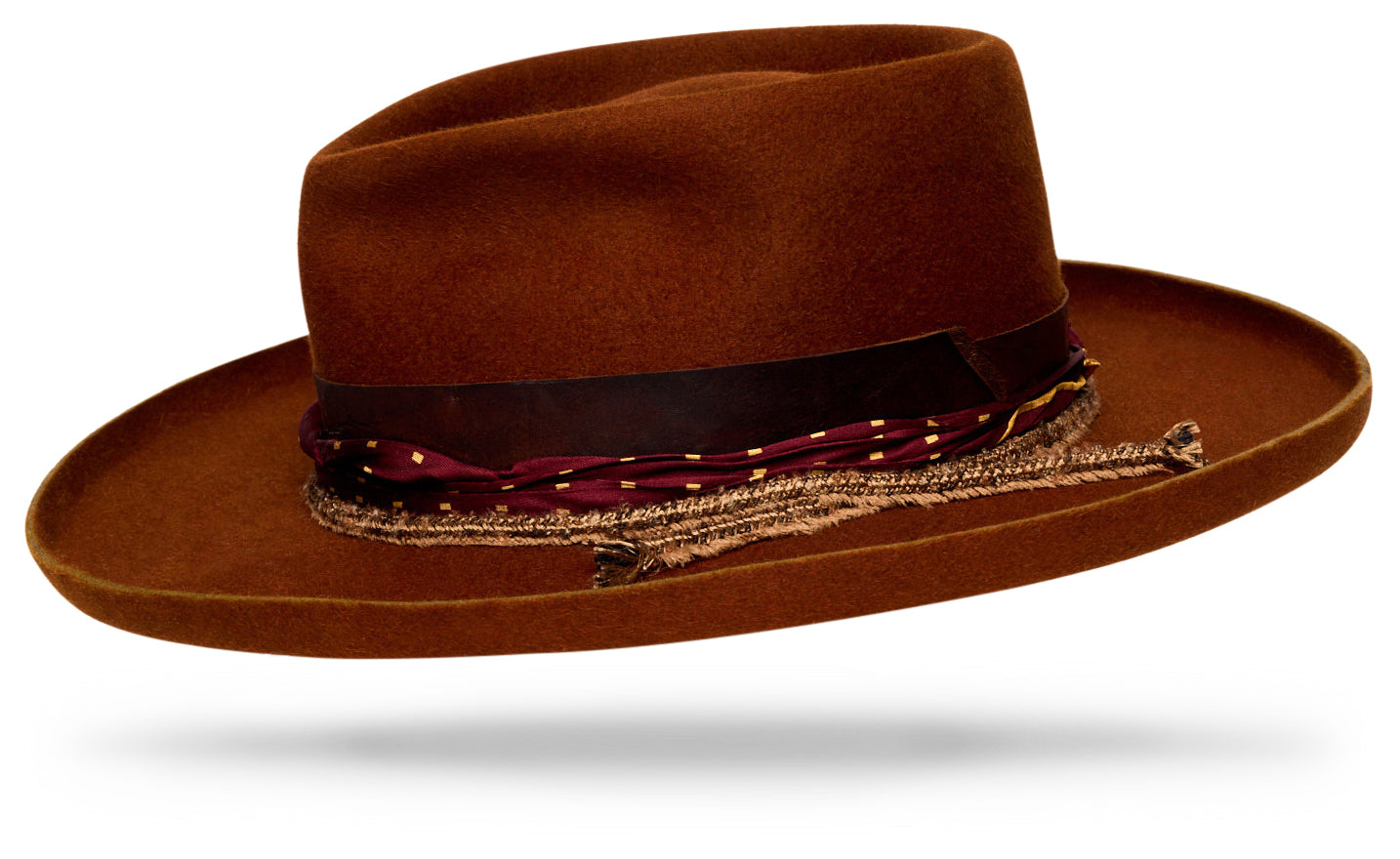 Design
Inspired by the legendary filmmaker Sergio Leone, master of the Spaghetti Western, this hat captures the duality of his world — Italian refinement with a rugged Western edge.The Leone carries that cinematic grit: made for those who wear elegance with a hint of defiance. Crafted in our new Blaze color, the tone recalls sun-scorched earth and a fistful of firelight. The Leone — a study in grit, grace, and pure character.
Material
100% Western Beaver Fur Felt Hat sustainably acquired. Natural dyeing minimizes the harmful effects on the surrounding environment. Our custom hats are hand dyed by using plants and vegetables base pigments.
Specifications
- The pencil curl brim (4”) and hand-shaped teardrop crown (4”) bring bold proportion and timeless presence. Finished with a hand-rolled silk band, woven silk-and-cotton trim, and an Italian leather edge, it balances raw character with quiet sophistication. - Handcrafted in our atelier in NYC. - Please allow 6-8 weeks to custom make this special piece.