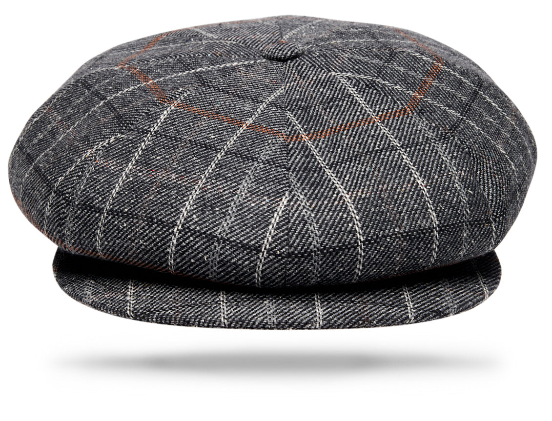 Design
A refined interpretation of the classic Apple Jack cap, crafted from a luxurious blend of silk and cotton. The charcoal grey cloth is distinguished by a subtle windowpane pattern, adding depth and a tailored sophistication to the fabric.Woven in County Donegal, Ireland, the cloth is then brought to Italy, where each cap is handmade by skilled artisans.The generous eight-panel construction creates the distinctive, fuller silhouette of the Apple Jack, while the refined windowpane gives this statement shape an elegant, sartorial character. Fully lined for comfort.
Material
55% Silk · 45% Cotton·
Specifications
- 55% Silk- 45% Cotton- Woven in Ireland- Handmade in Italy
